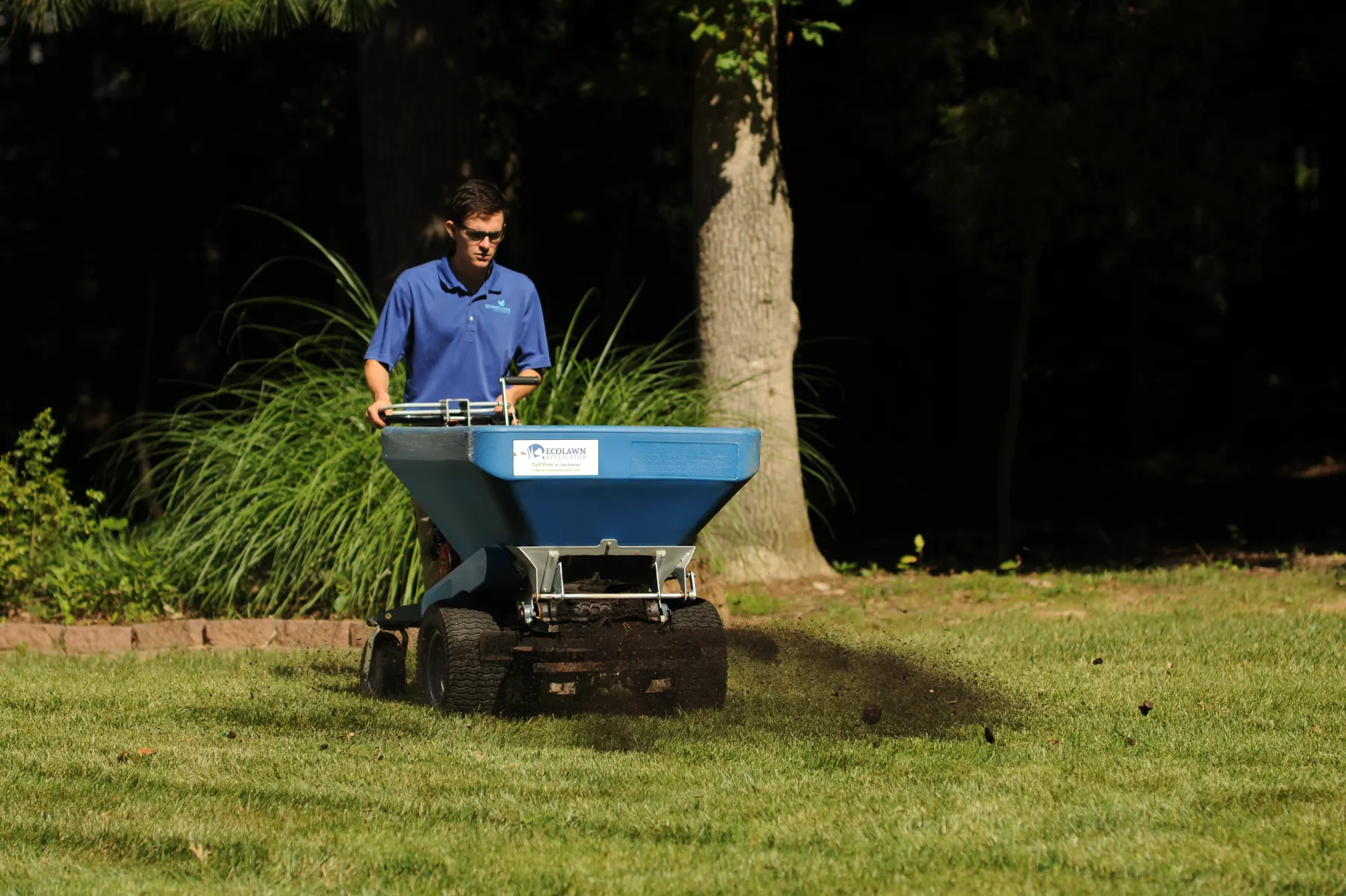 Compost being evenly topdressed across a Virginia lawn